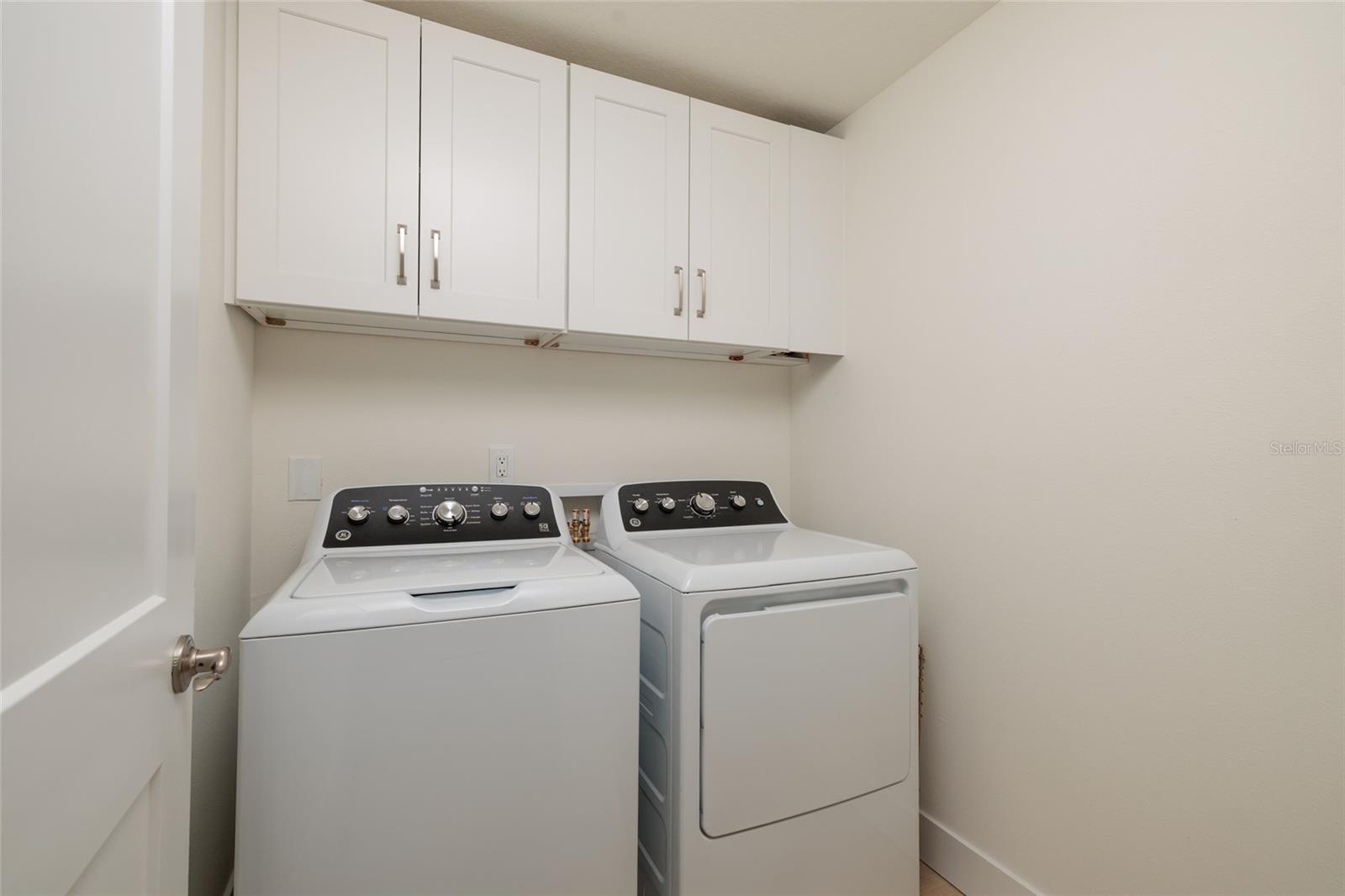 Dedicated inside laundry room with  convenient storage and room for full-sized appliances.