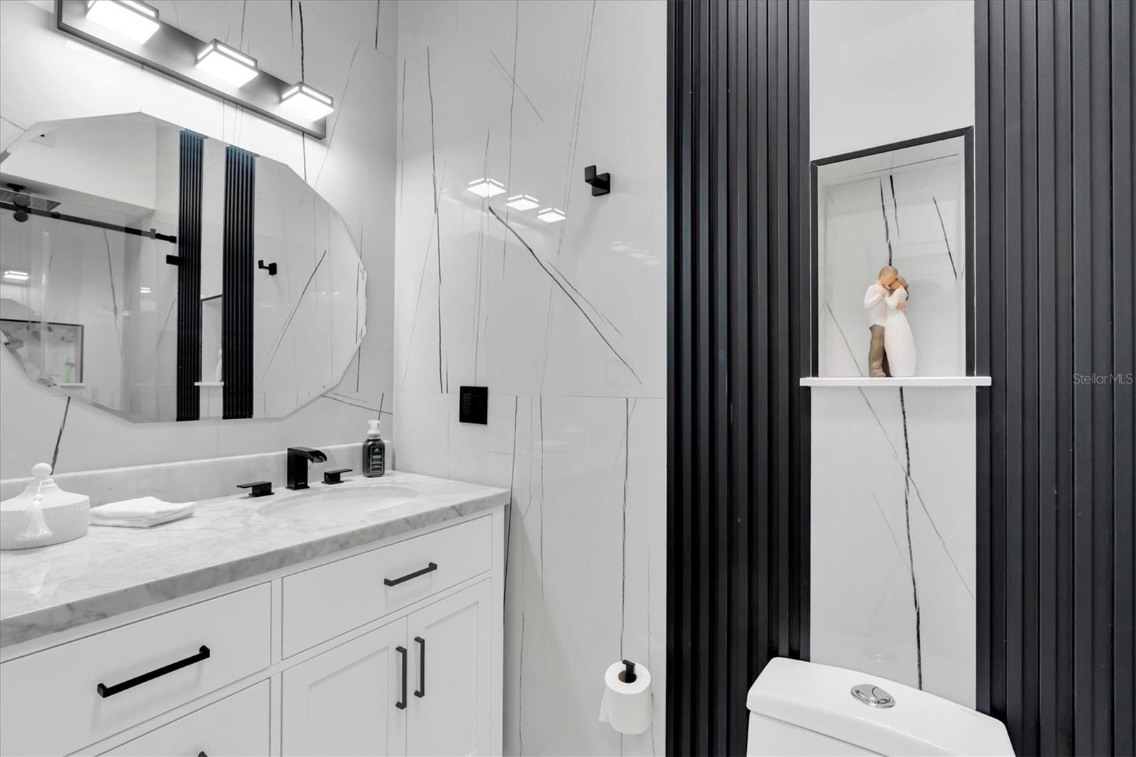 The primary bathroom, private to the bedroom, features clean lines and a beautifully appointed glass-door shower.