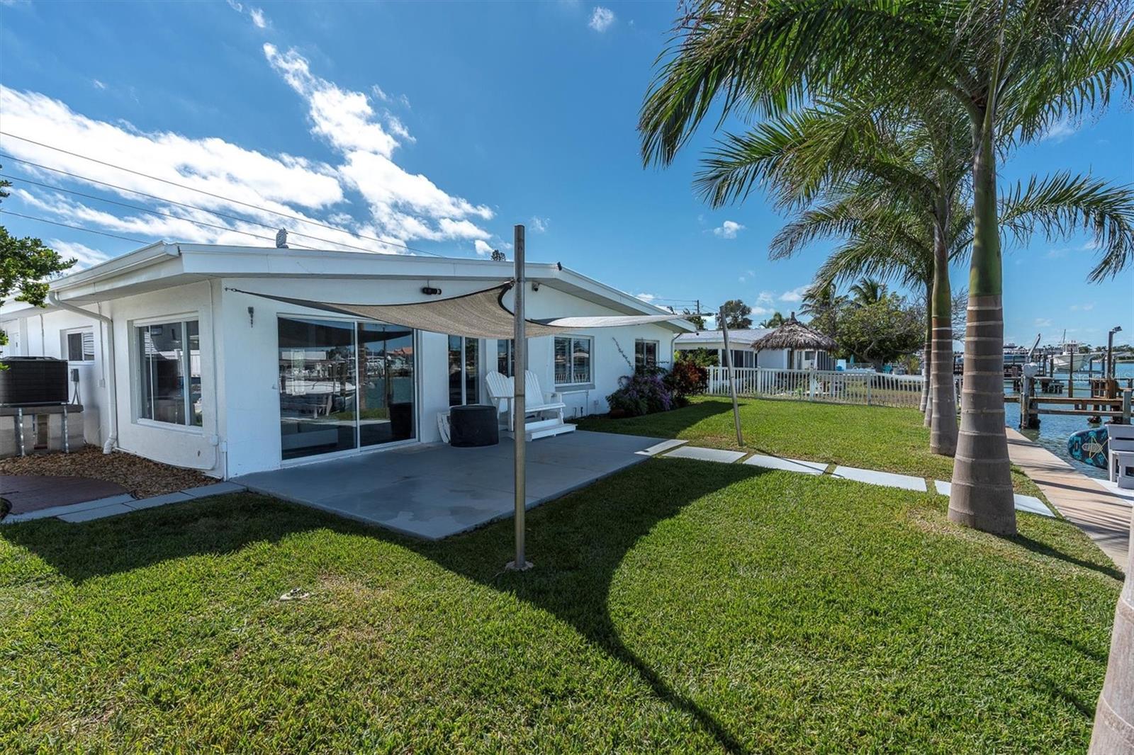 Spacious backyard featuring tropical landscaping, towering palms, and stunning water vistas.  The backyard setting is perfect for quintessential Florida living.