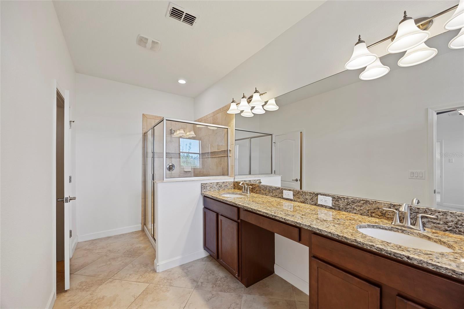 Primary Bathroom with granite countertops and double sinks