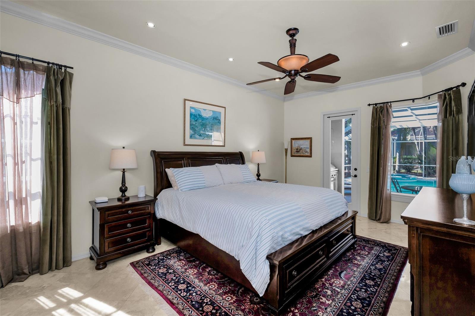 Primary bedroom w/ensuite bathroom and door to patio