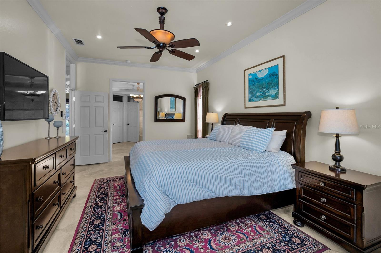 Primary bedroom w/ensuite bathroom and door to patio