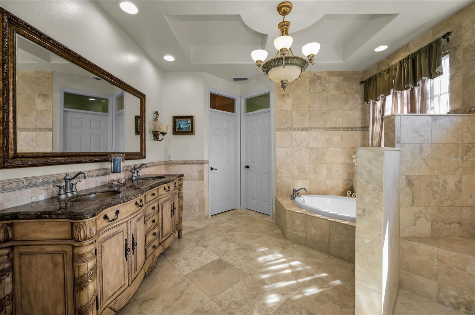 Primary bathroom w/tray ceiling, double sinks, soaking tub, large walk-in shower, water closet and walk in closet