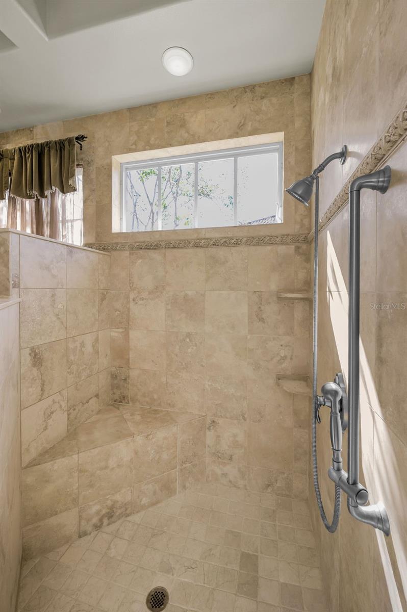 Primary bathroom walk-in shower with built in bench