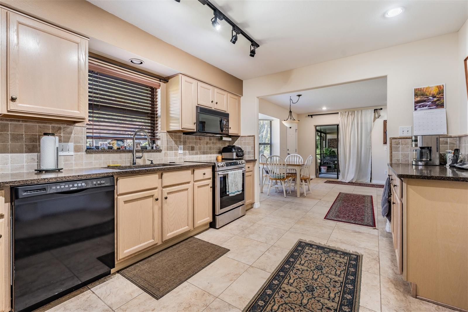 Kitchen with tile flooring, granite counter tops, open to the kitchen table area