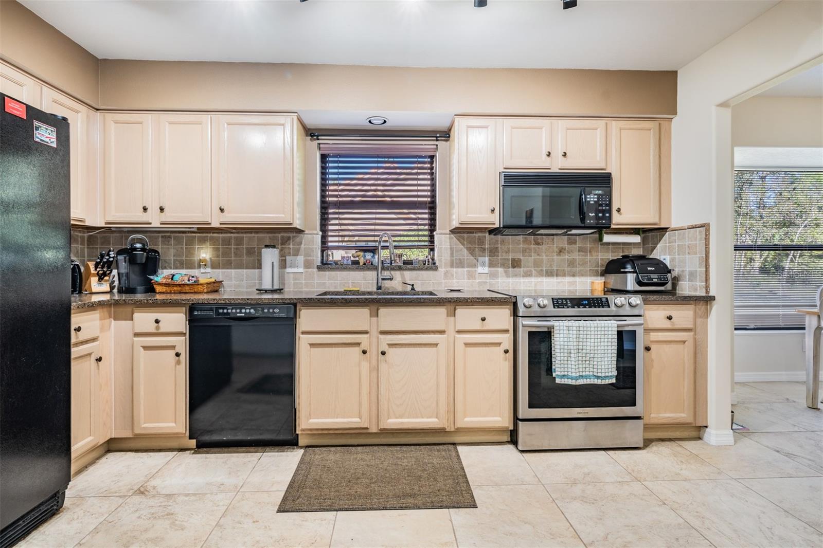 Kitchen with tile flooring, granite counter tops, open to the kitchen table area