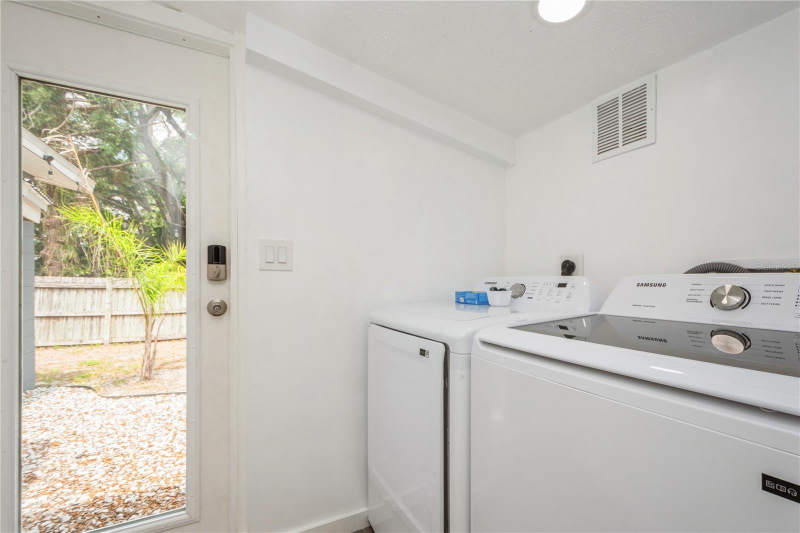 Spacious laundry room with ample natural light and view of backyard.