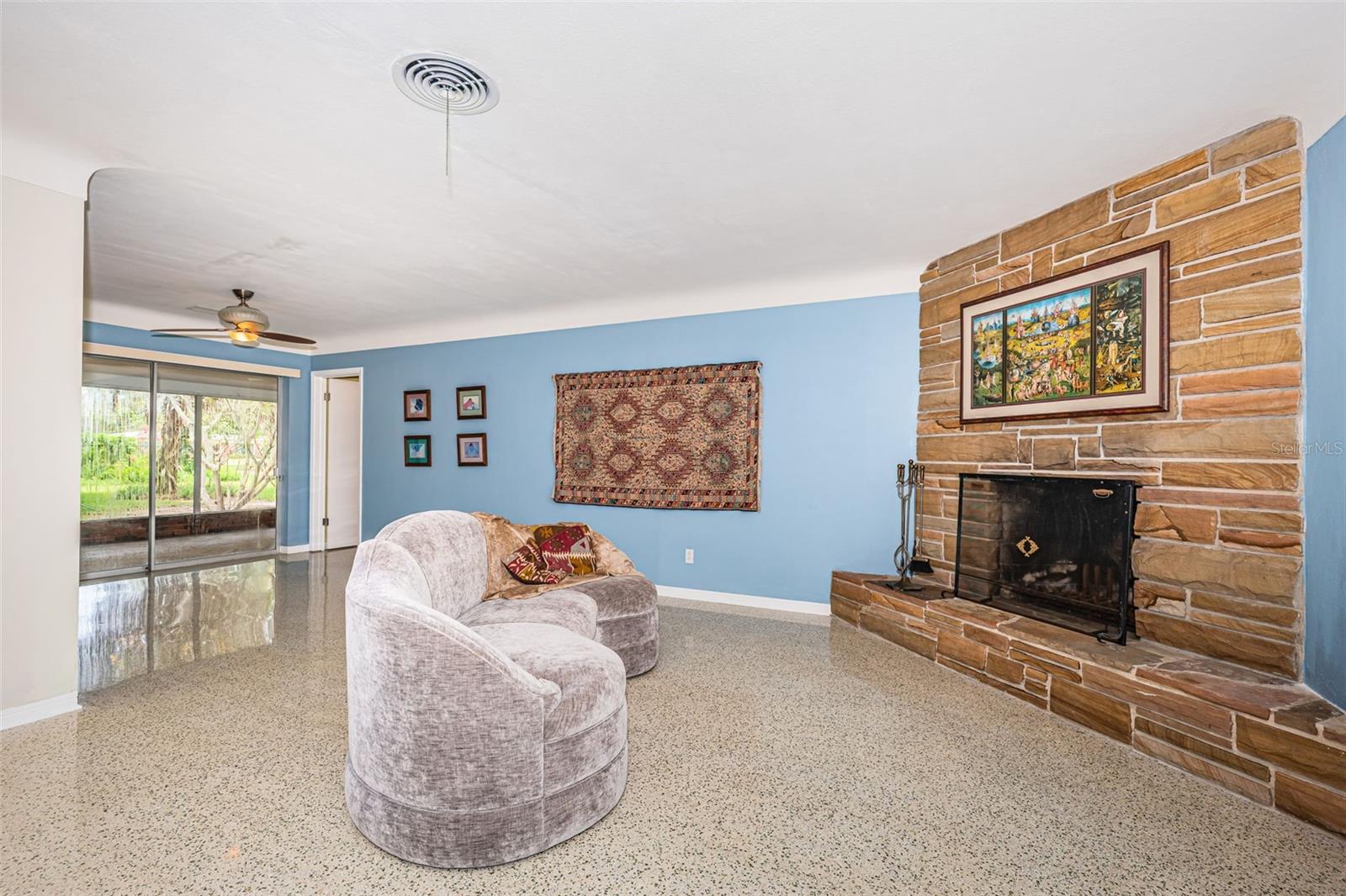 Living room flanked by wood burning stone fireplace.