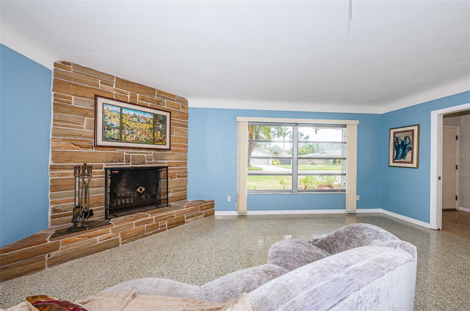 Living room flanked by wood burning stone fireplace.