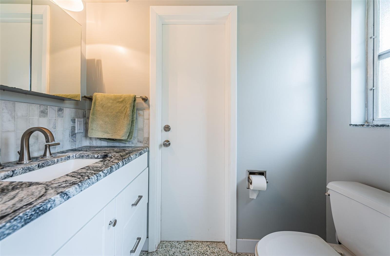 1/2 bathroom off of front bedroom and connected to garage.