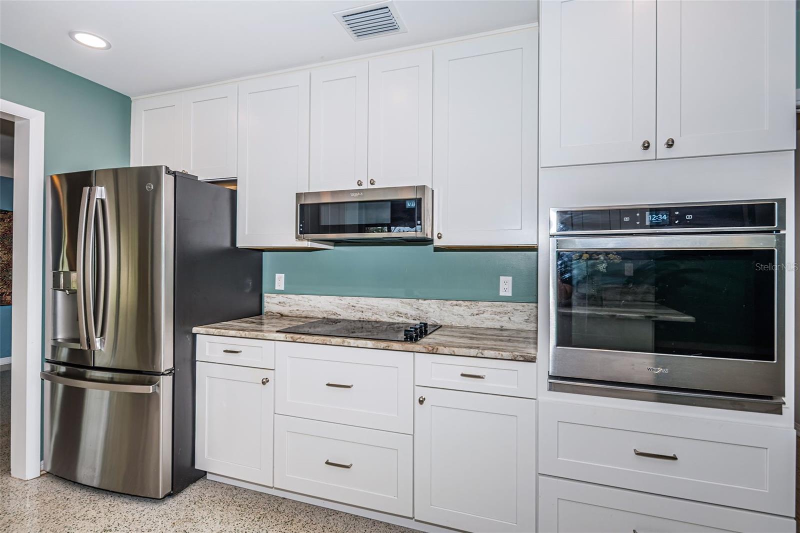 Updated kitchen with solid wood cabinetry, quartz counters, and stainless appliances.