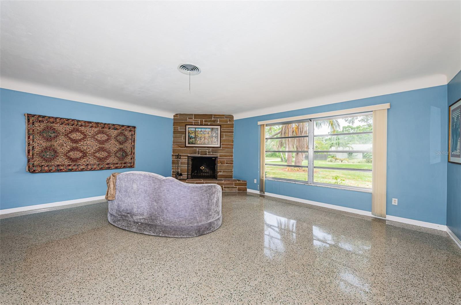 Living room flanked by wood burning stone fireplace.