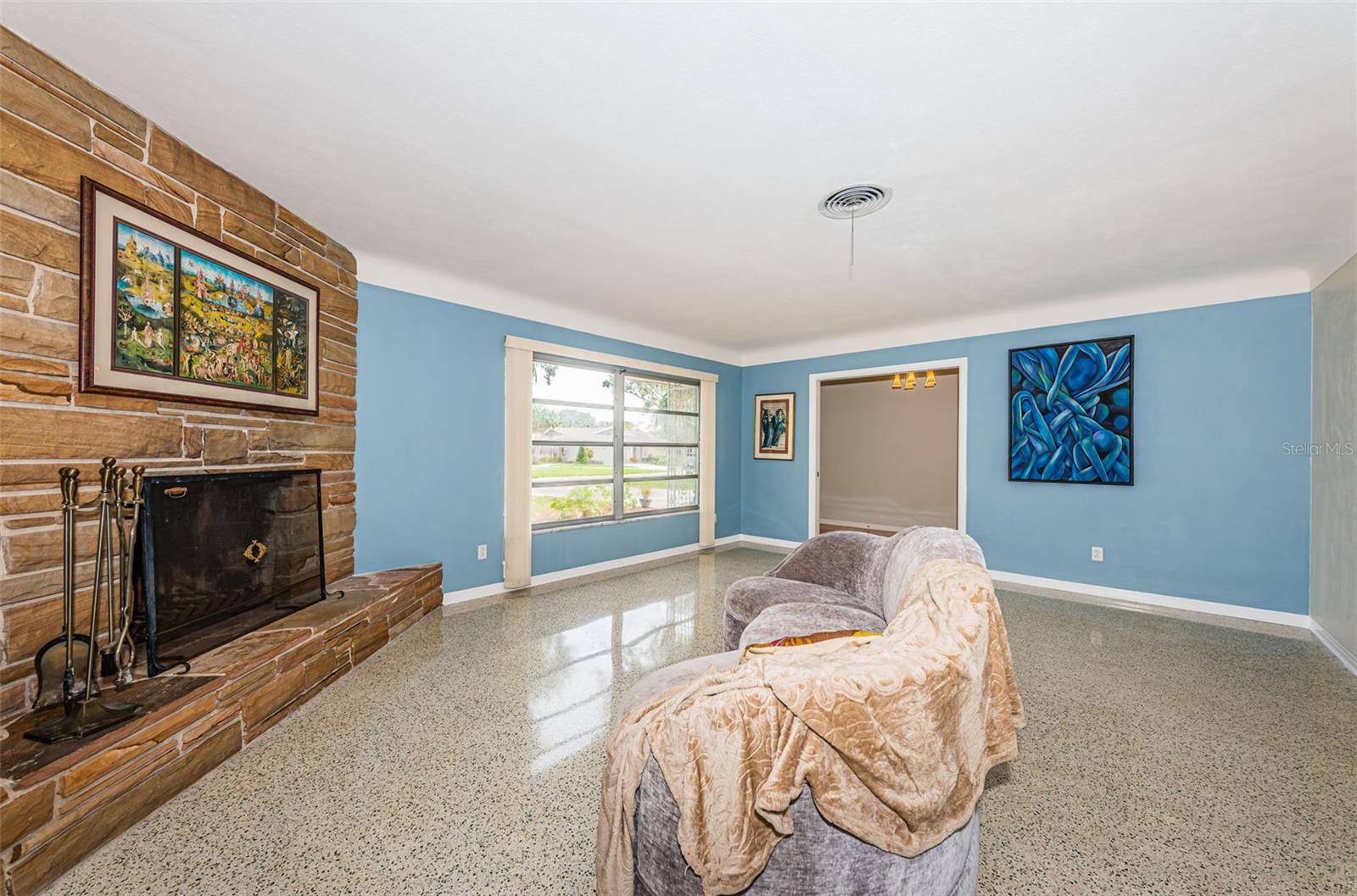 Living room flanked by wood burning stone fireplace.