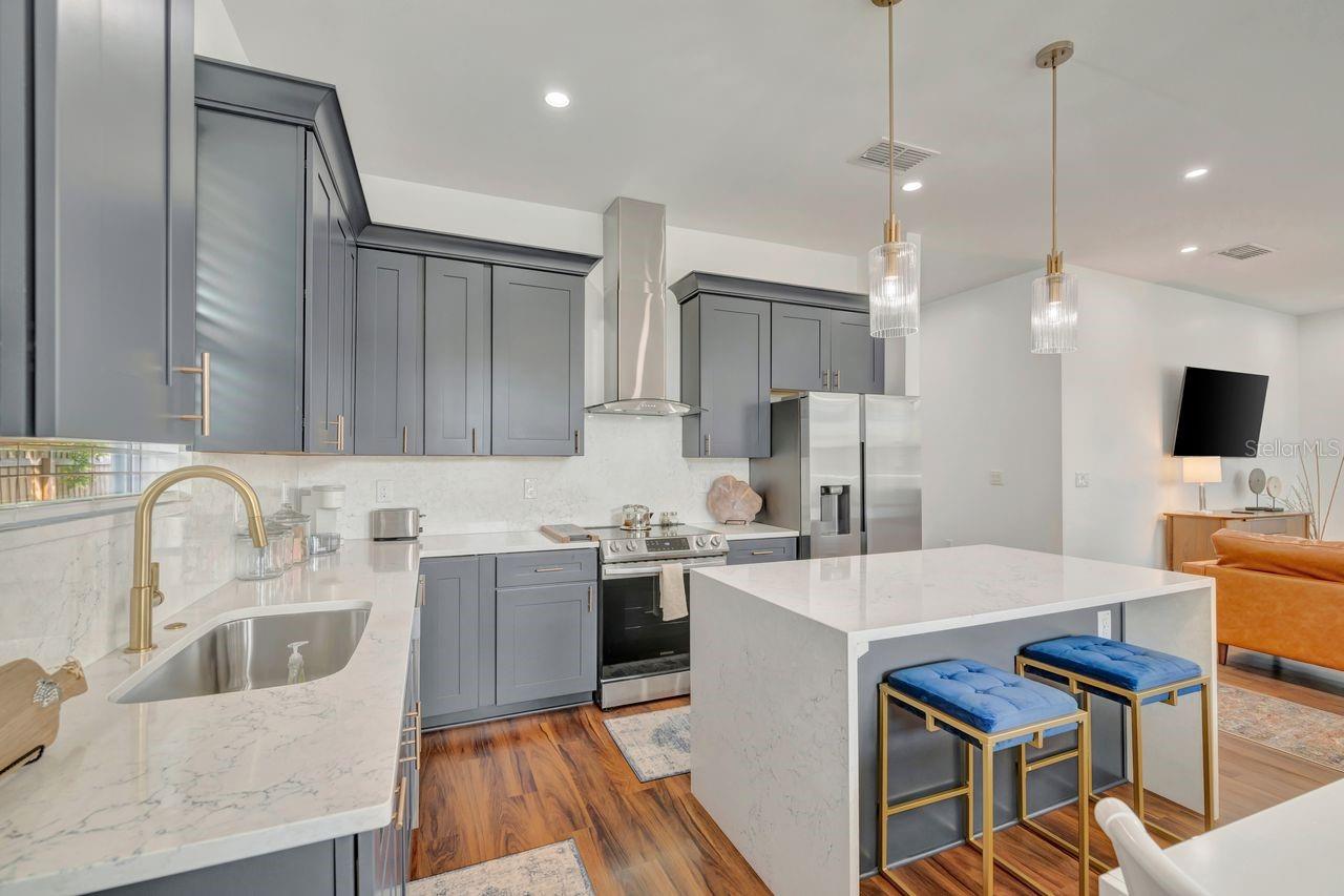 Designer kitchen with 42-inch upper cabinets, quartz counters and back splash