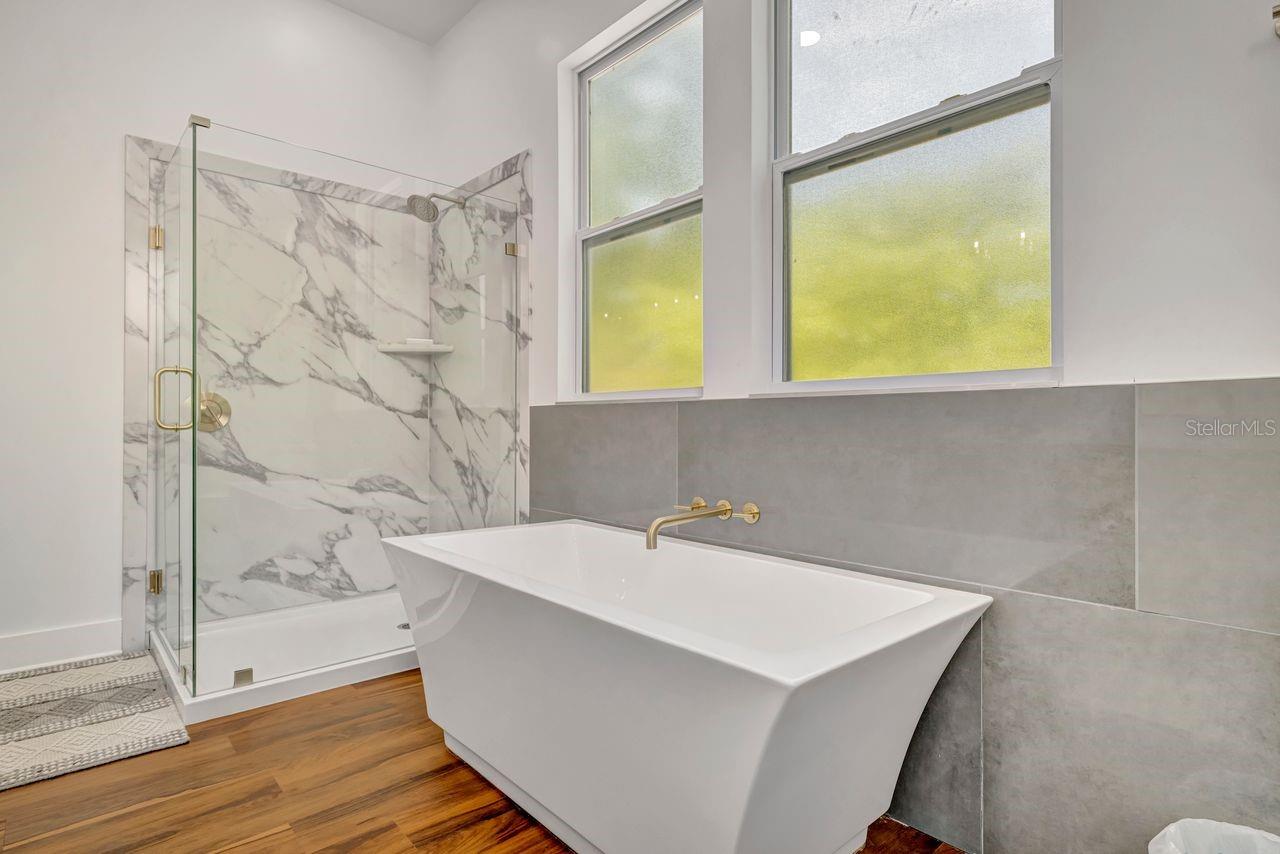 Primary bath has both a grand soaking tub and glass enclosed shower.