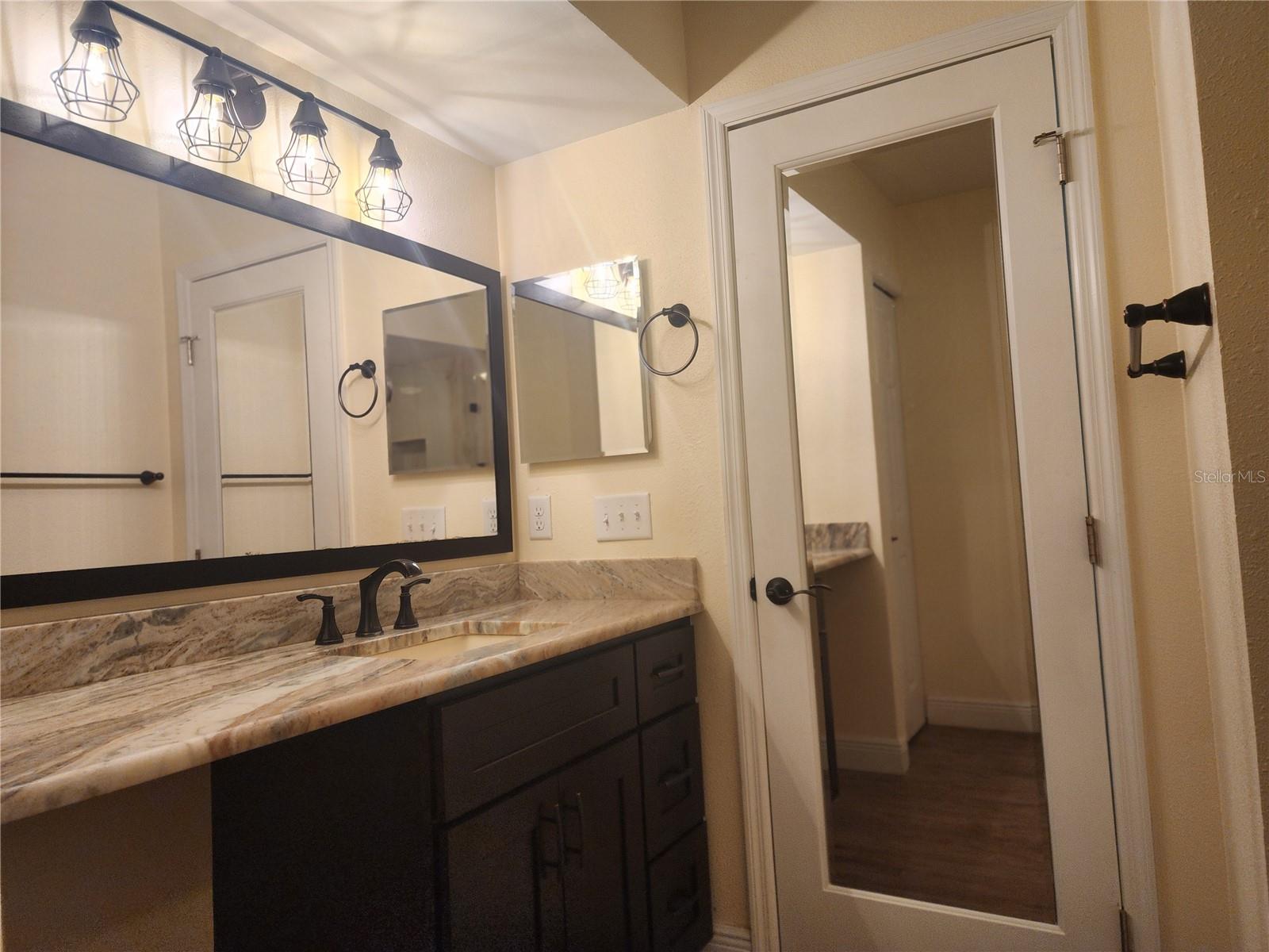 Master Bath with Vanity Sitting Area and Mirrored Doors
