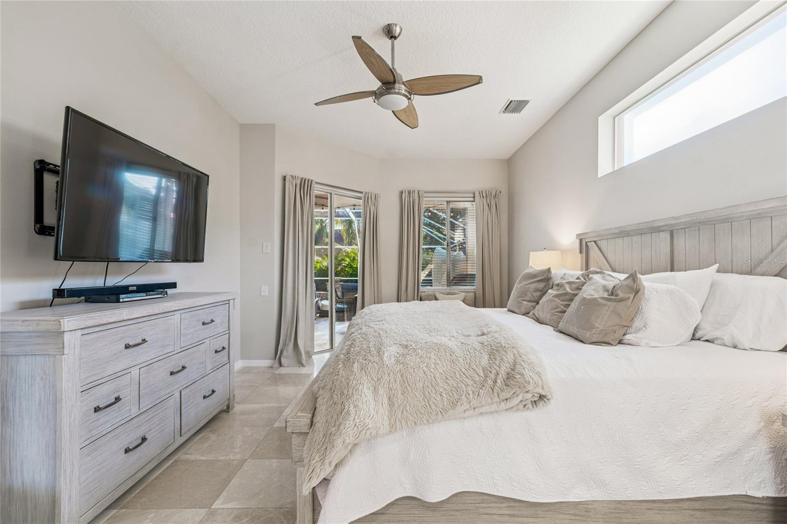 Primary bedroom with view of the pool and waterfall