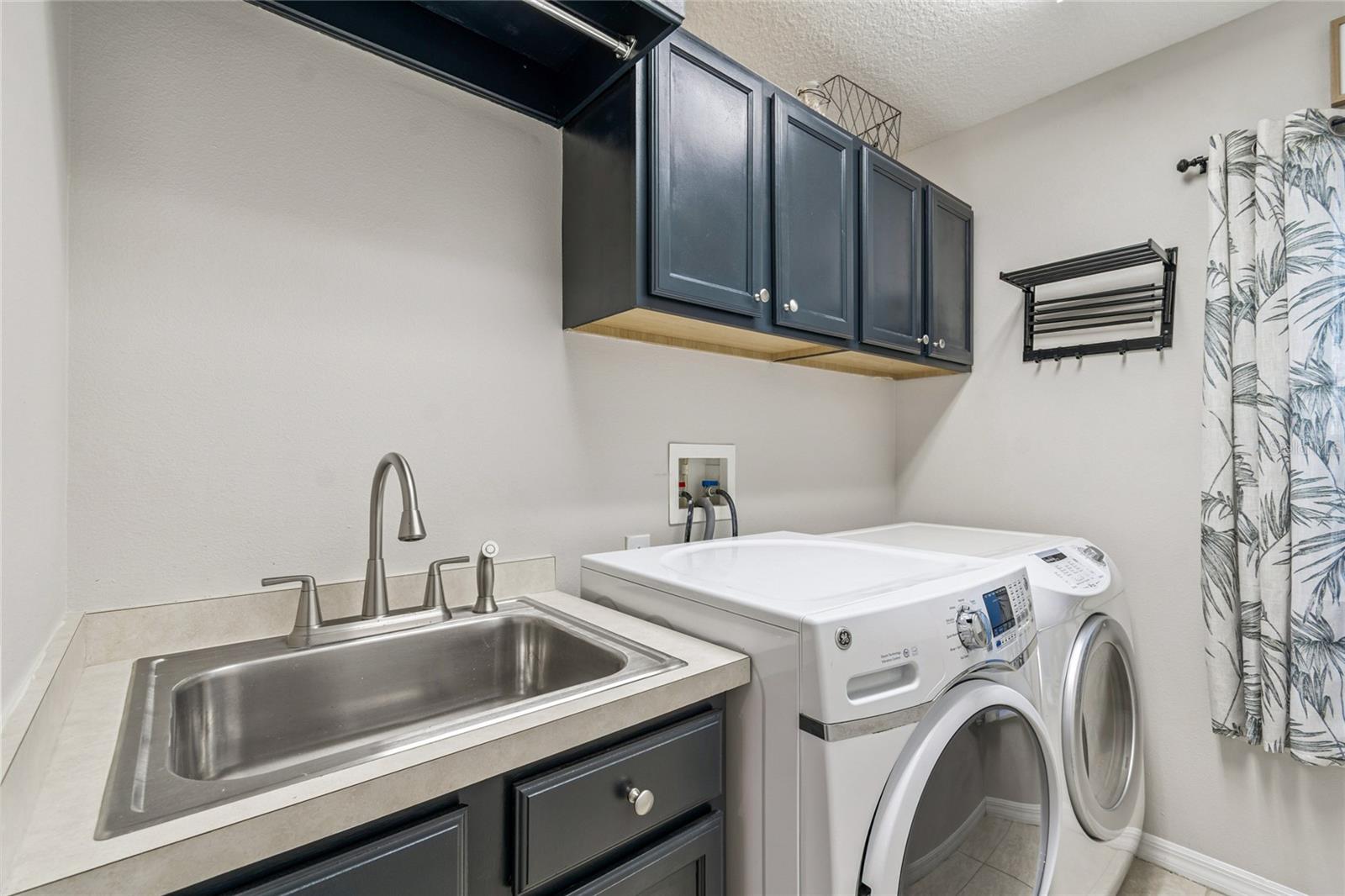 Laundry room with painted cabinets and laundry tub
