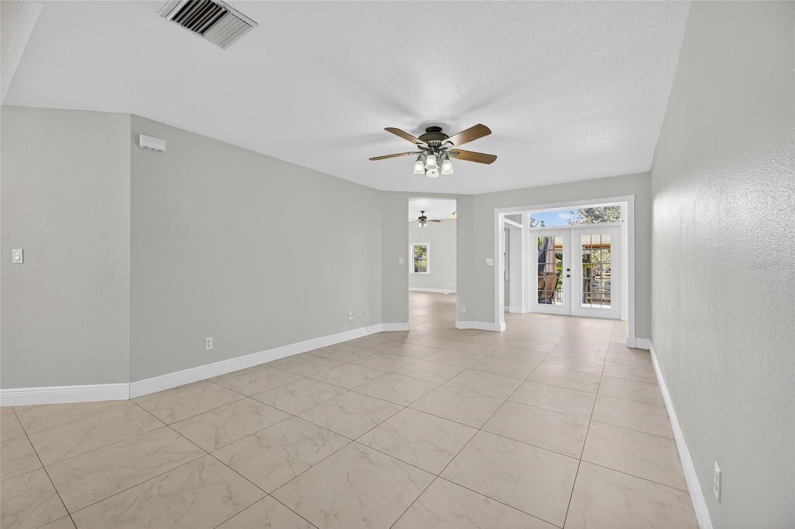 This large living room is just inside the home with the view of the water out the french doors.
