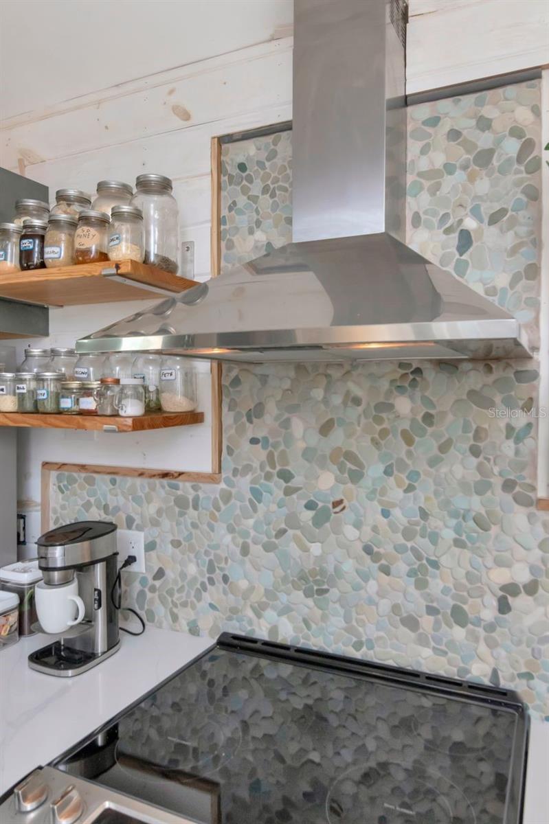 Brand new stove, vent with a beautiful rock back splash.