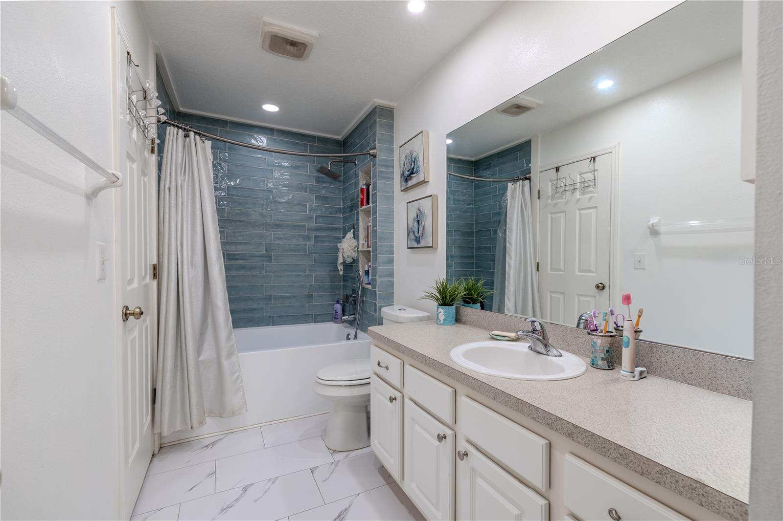 The main bath balances streamlined design with indulgent function. A deep tub and shower combination with dual shower heads delivers versatility and comfort, while recessed wall shelving maintains clean lines and clutter-free simplicity.