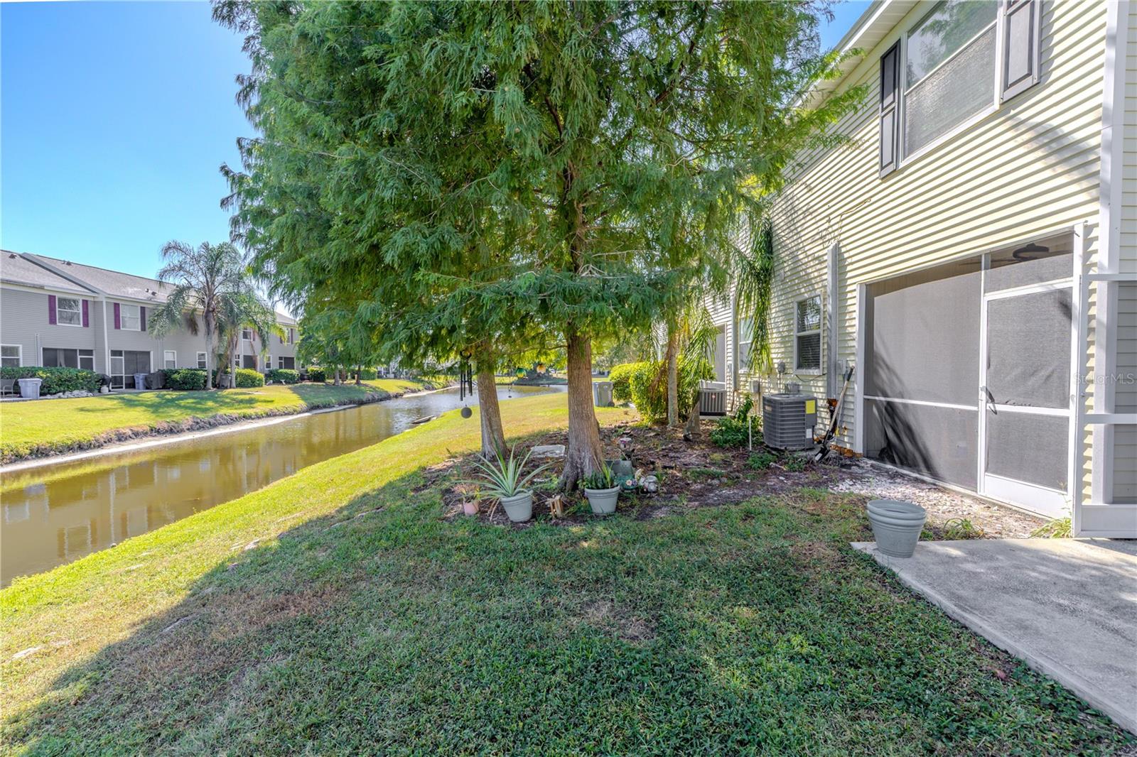 The backyard offers clean, unobstructed water views complemented by well-placed shade trees. The combination of open space, natural beauty, and subtle greenery creates a simple, serene outdoor setting for living and leisure.