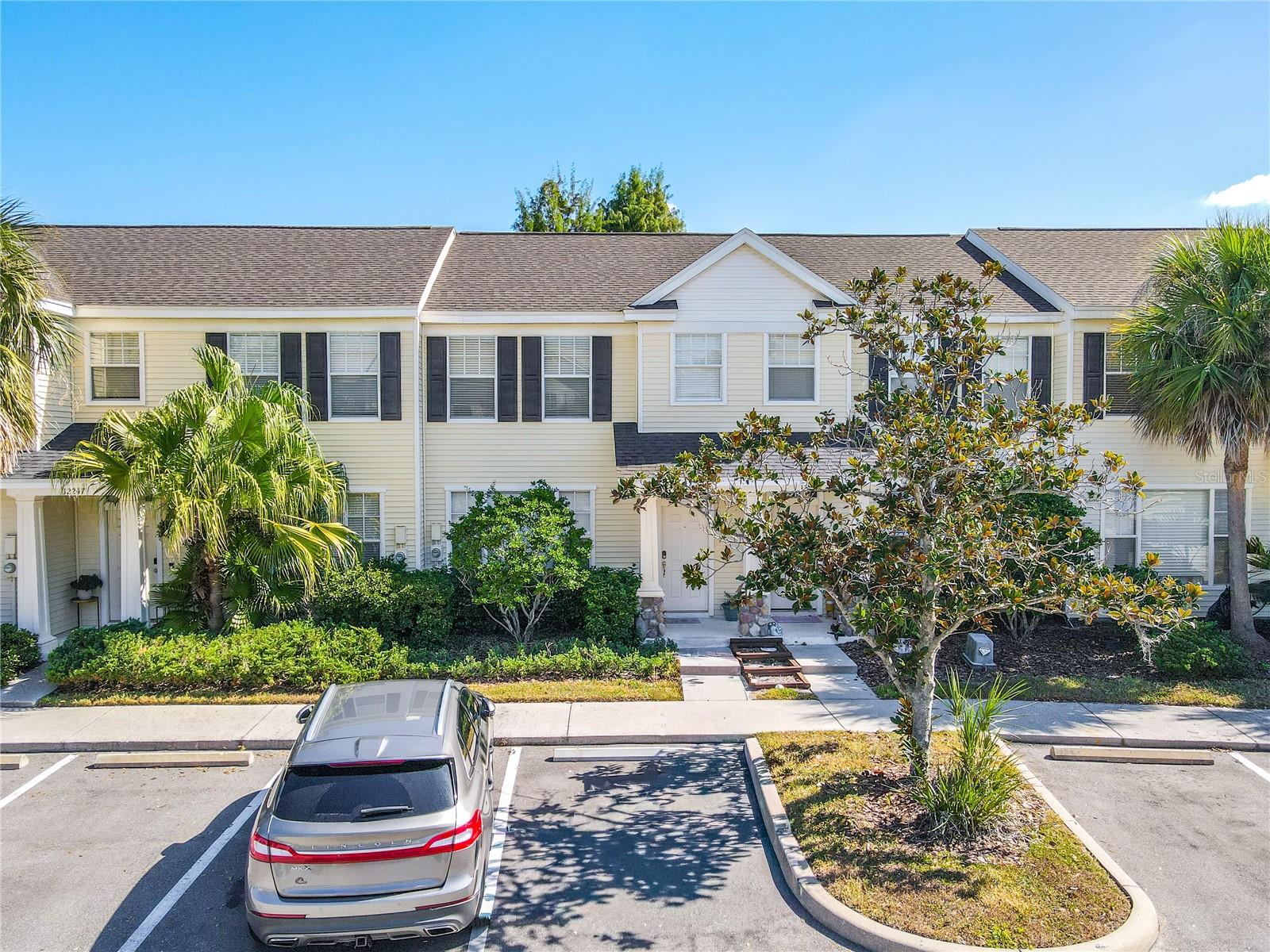 Cleanly organized parking spaces sit just steps from the front entrance, where well-maintained greenery adds a subtle pop of color and softness. The approach is simple, functional, and visually appealing—a seamless introduction to the home beyond.