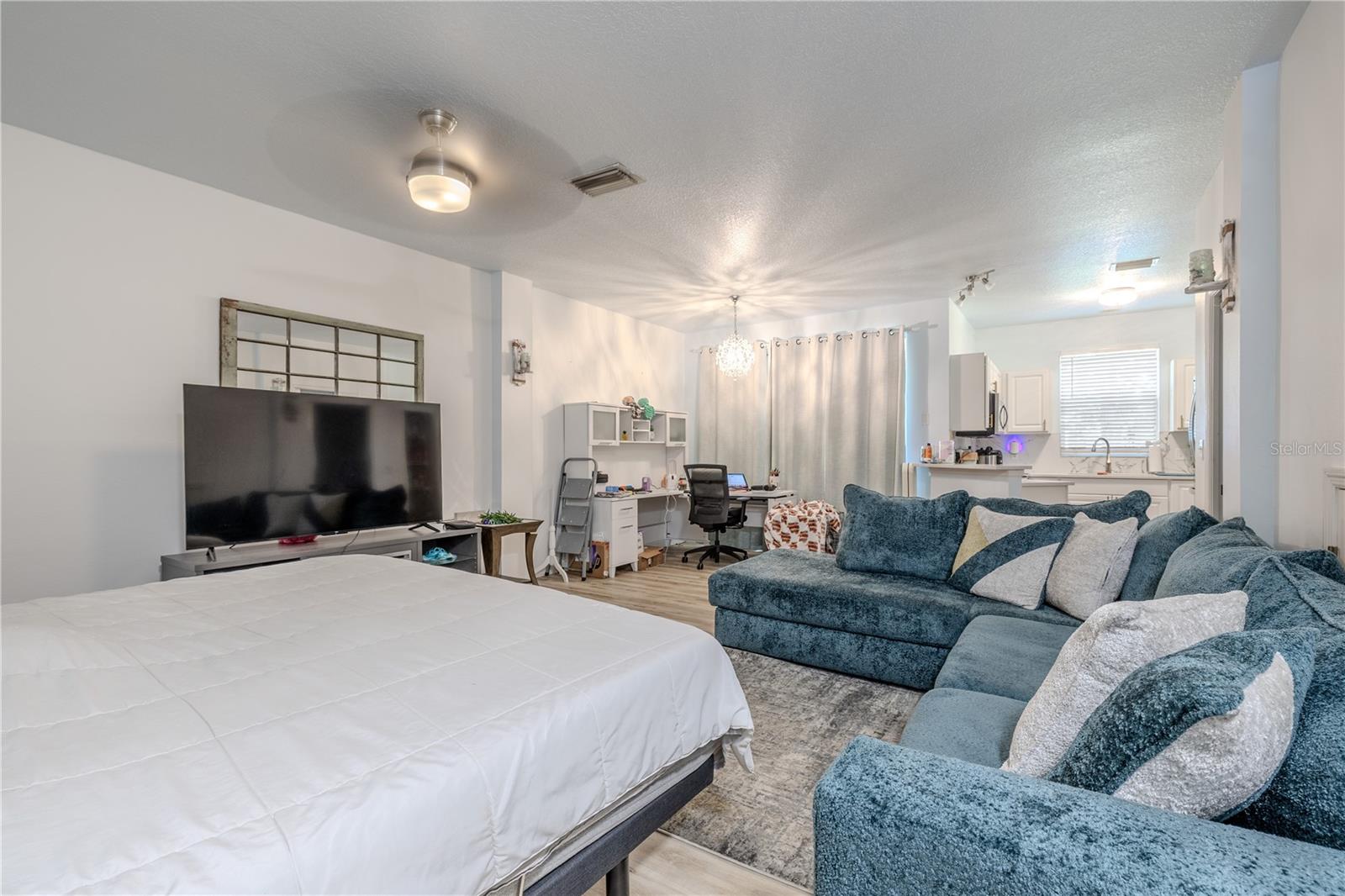 The entry opens directly into a spacious, interconnected living zone—an open-concept design where the living room, dining area, and kitchen exist as one cohesive environment. Light travels unbroken across the space, highlighting clean lines, intentional materials, and the modern art of functional flow.