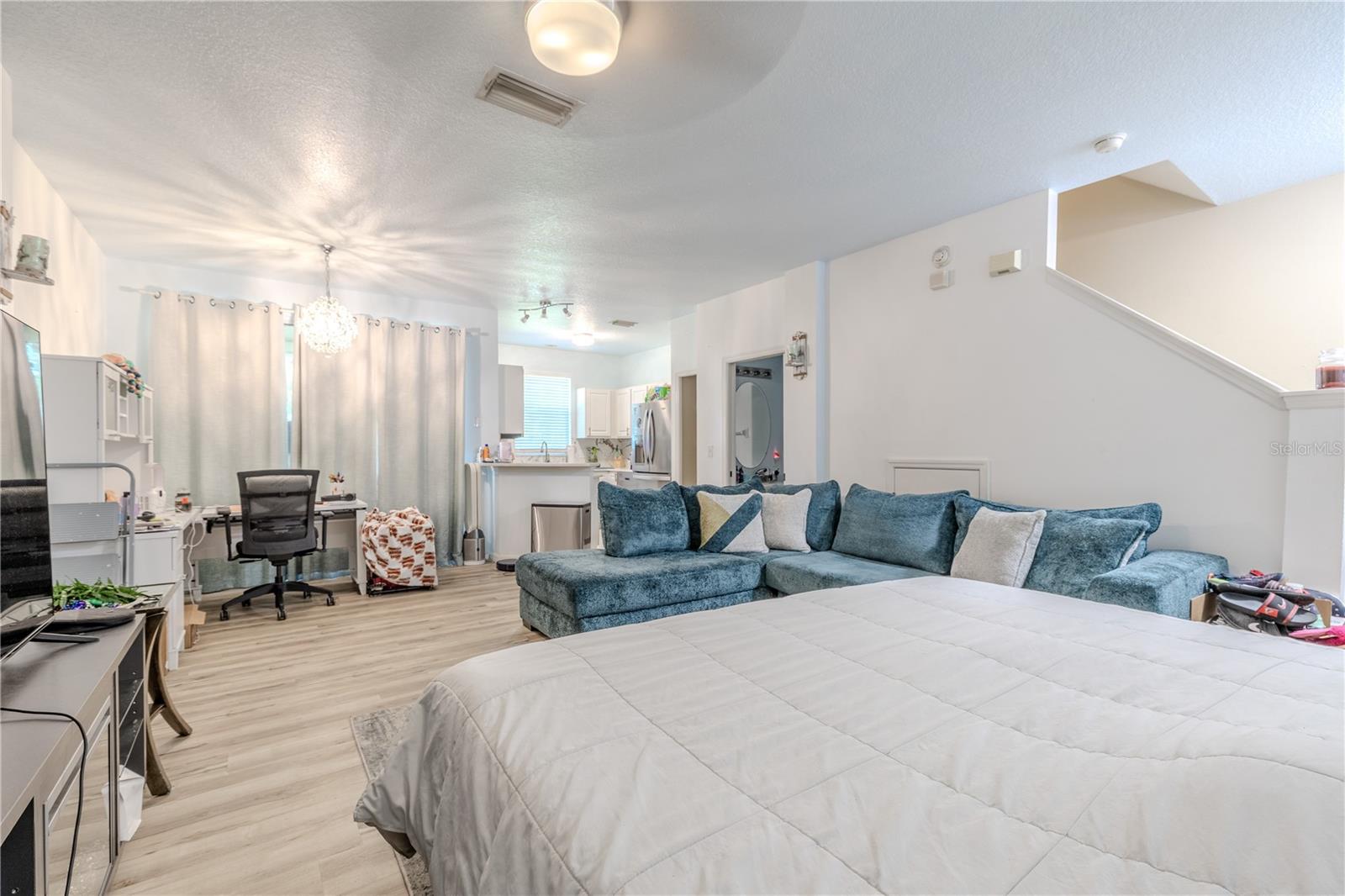 As you step further inside the space unfolds around you—a soft current of air, light, and warmth that moves freely through living, dining, and kitchen spaces without walls to confine it. The aroma of freshly brewed coffee mingles with the hum of conversation, and every surface seems to echo the ease of open living.