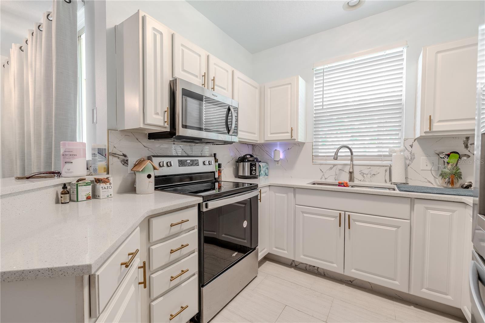 The kitchen rests like a heartbeat at the center of the home—compact yet alive with warmth.