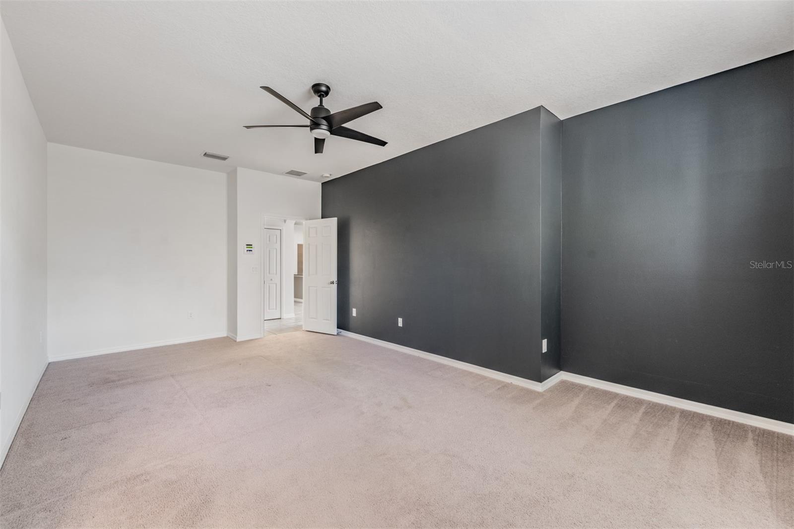 Spacious Master Bedroom with a ceiling fan/light fixture attached