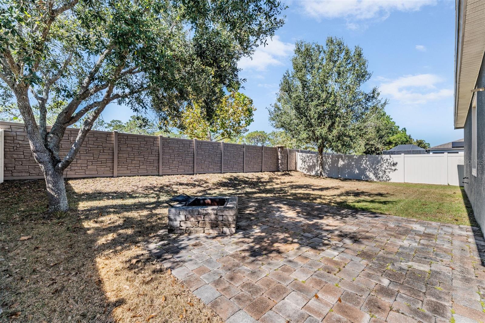 Fenced-in back yard Fire pit, pavered patio