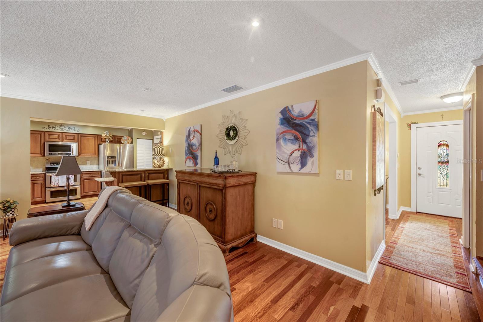 Living Room with view into Kitchen on left and Front Door on Right