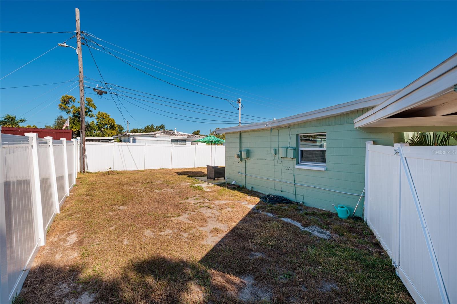 Side yard & private vinyl fence. On right is gate to the carport.