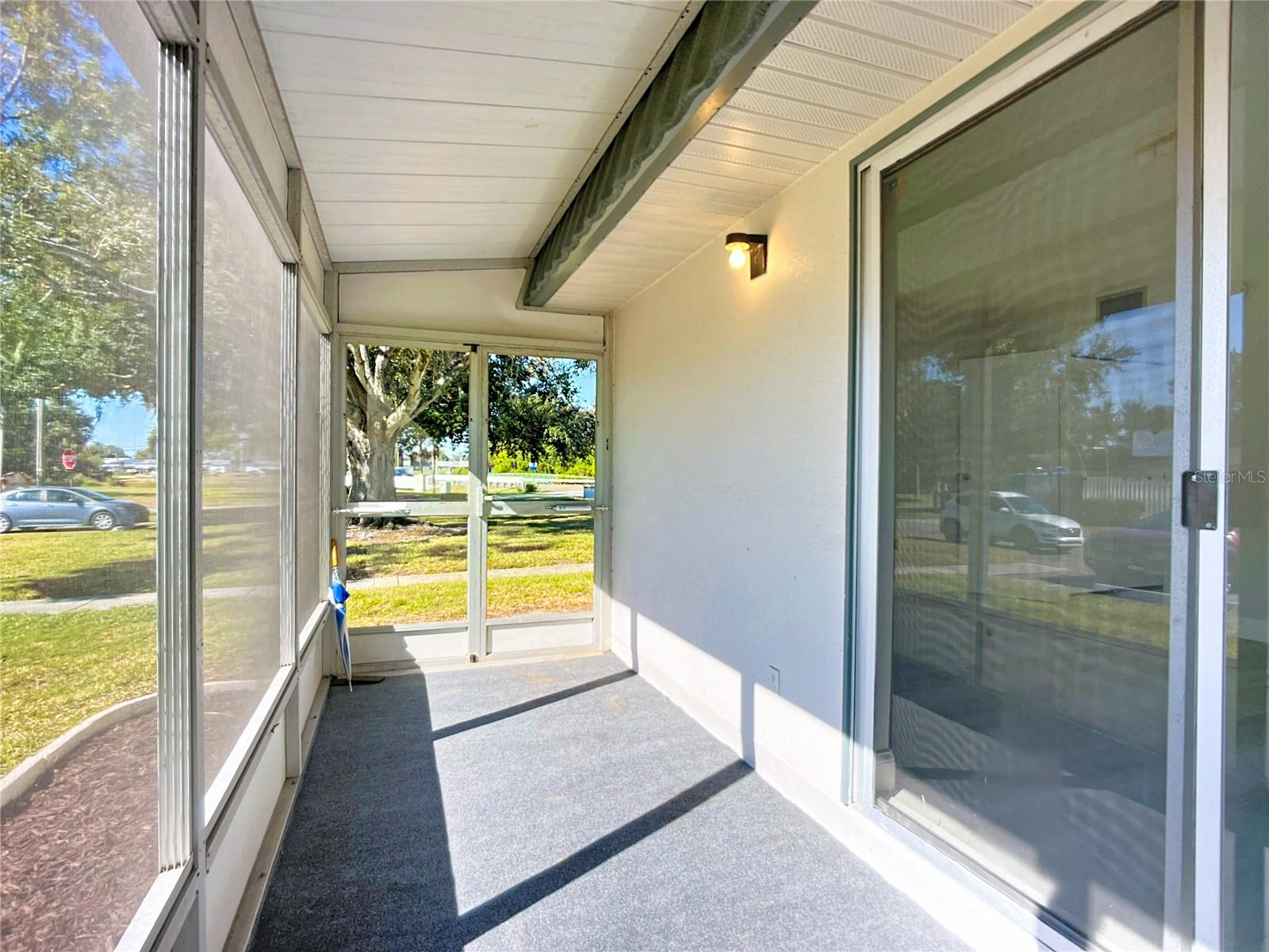screened porch with golf cart doors and view of open space