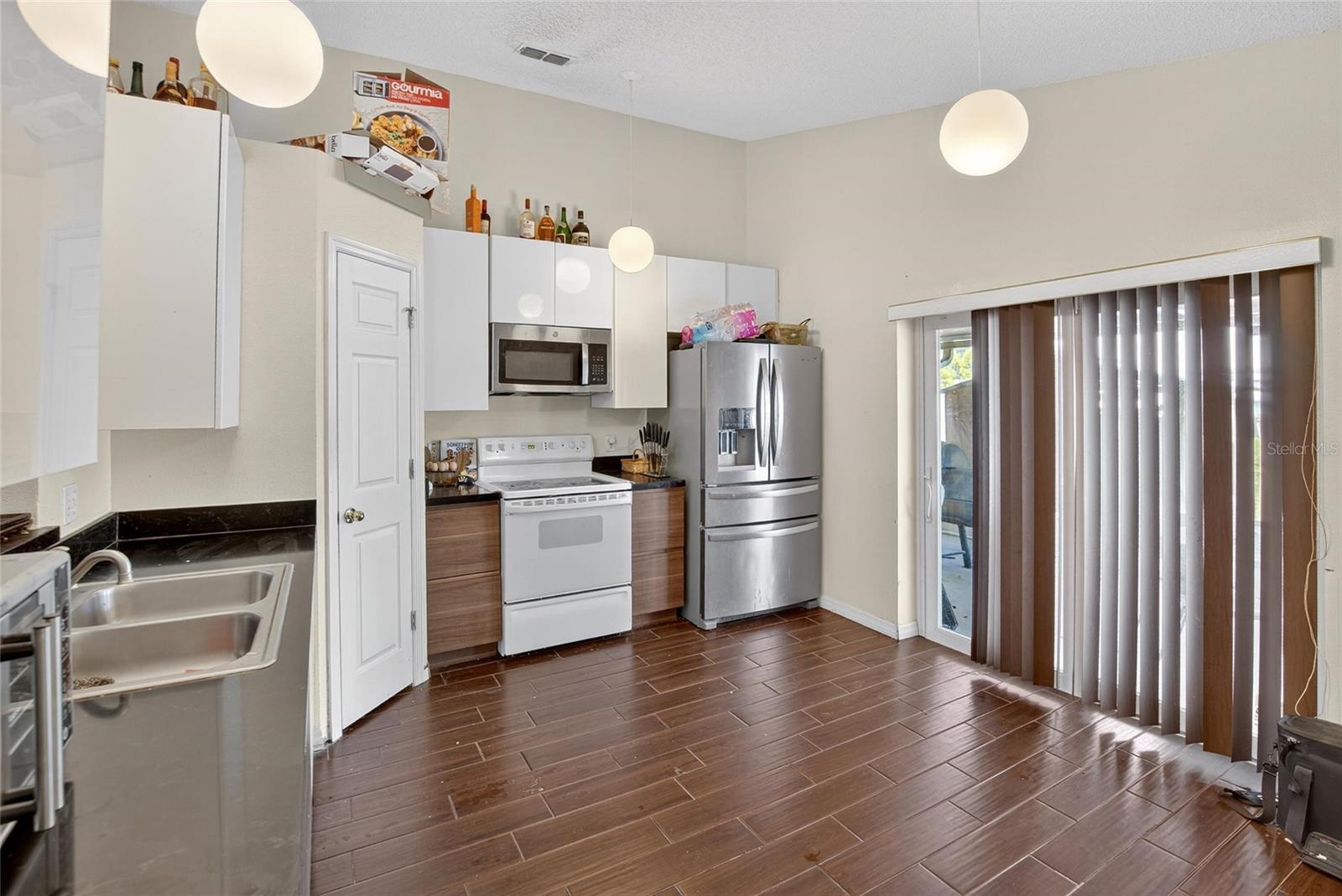 Kitchen.  Pantry door in the middle left.  Sliding doors to the patio to the right.