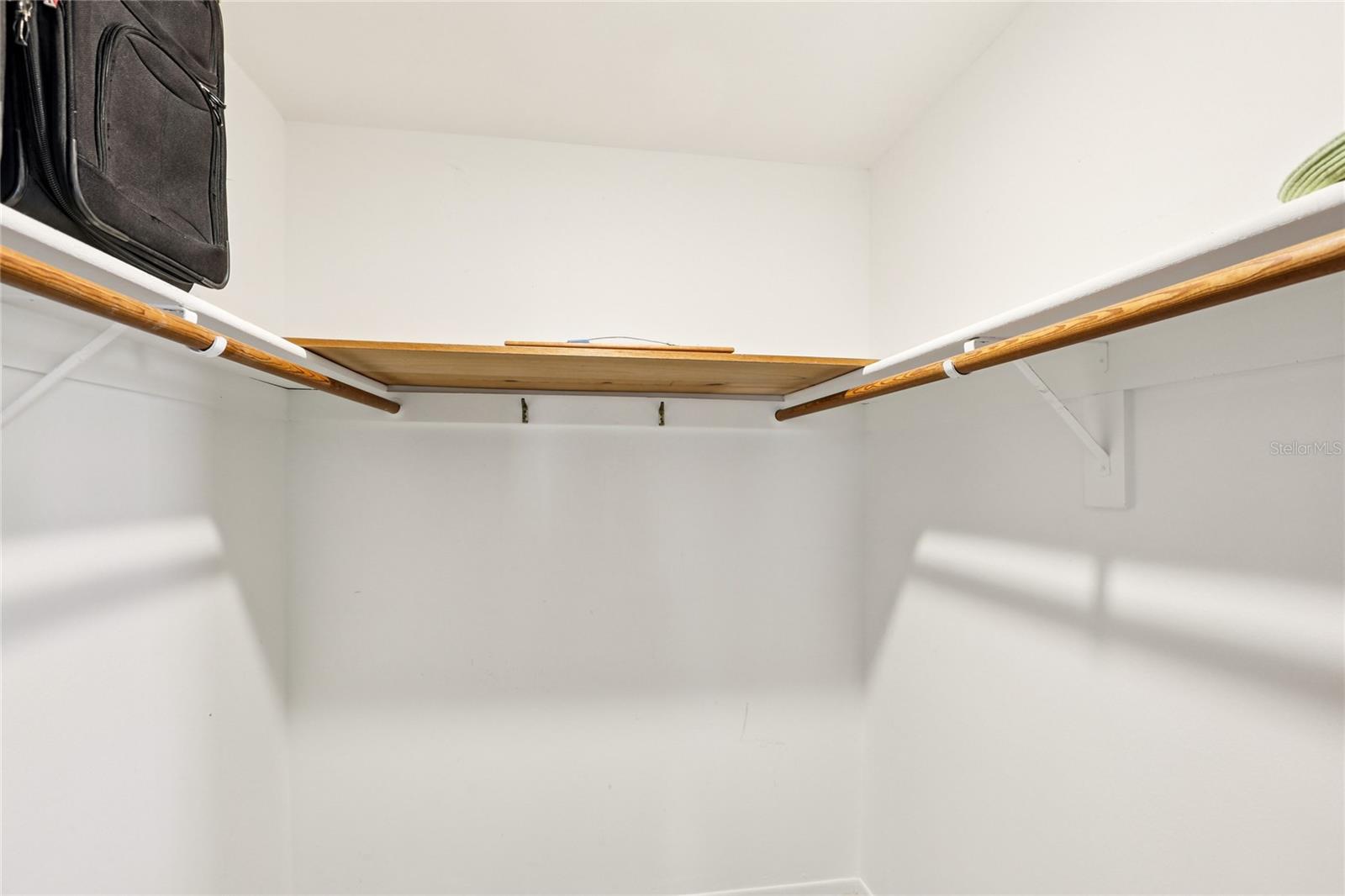 Spacious primary walk-in closet with abundant hanging space and shelving.