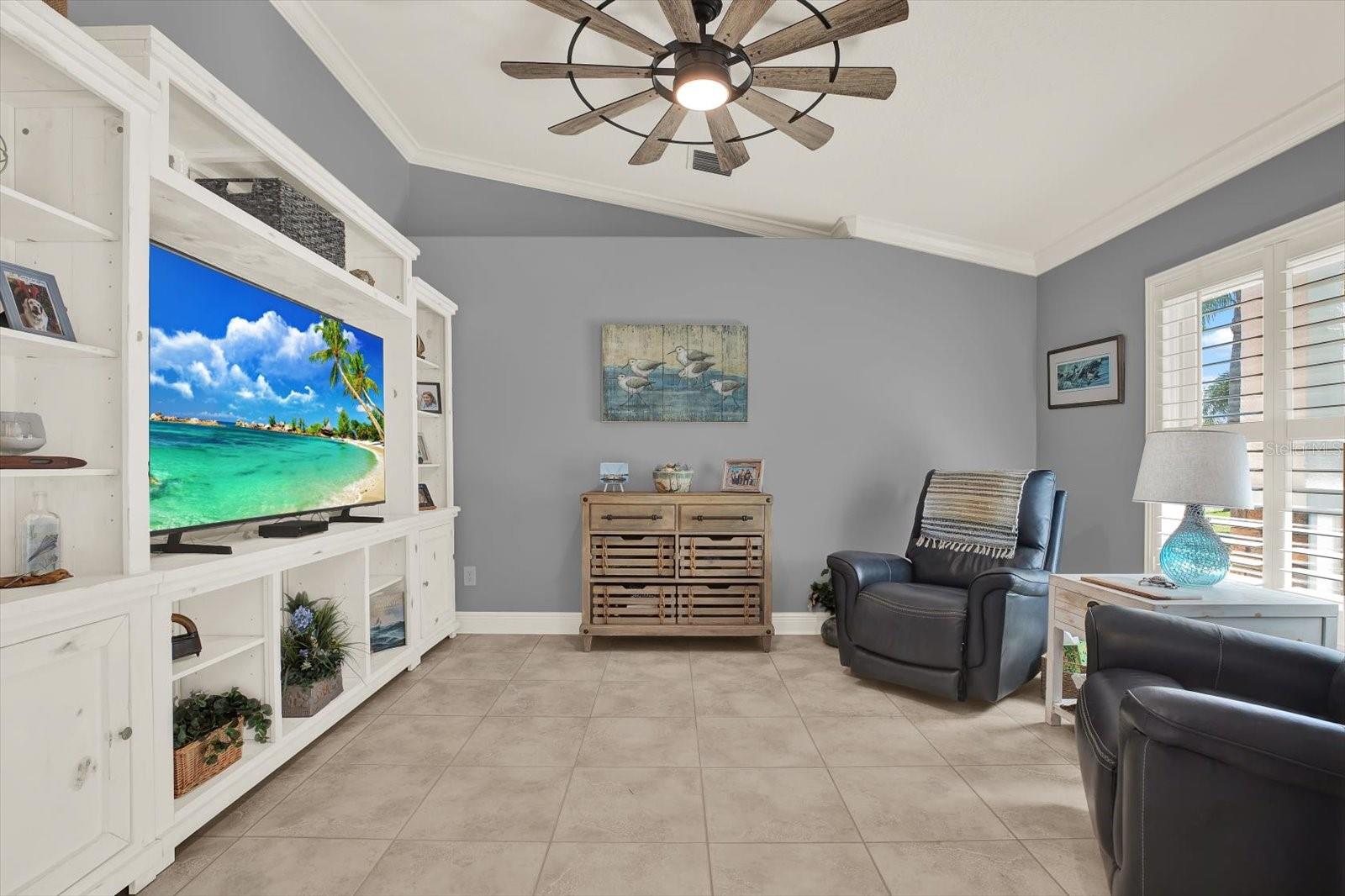 Comfortable den with high ceilings and plantation shutters