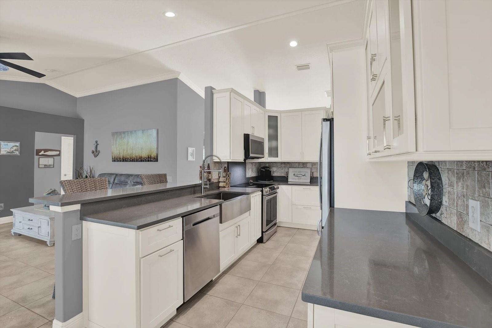 The open and spacious kitchen has been designed with clean lines, well-appointed upgrades that allow the kitchen to not only look beautiful but be a comfortable, functioning kitchen for the most discerning chef.