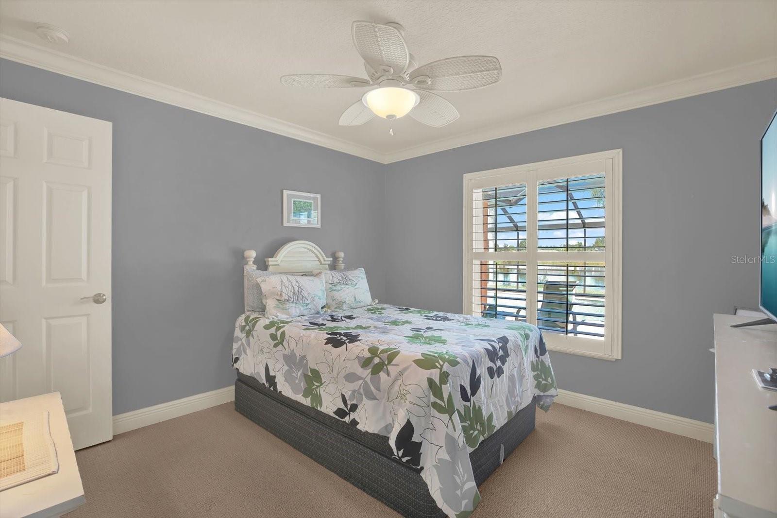 The second bedroom has an amazing view of the pool and the lake, and privacy when the plantation shutters are closed