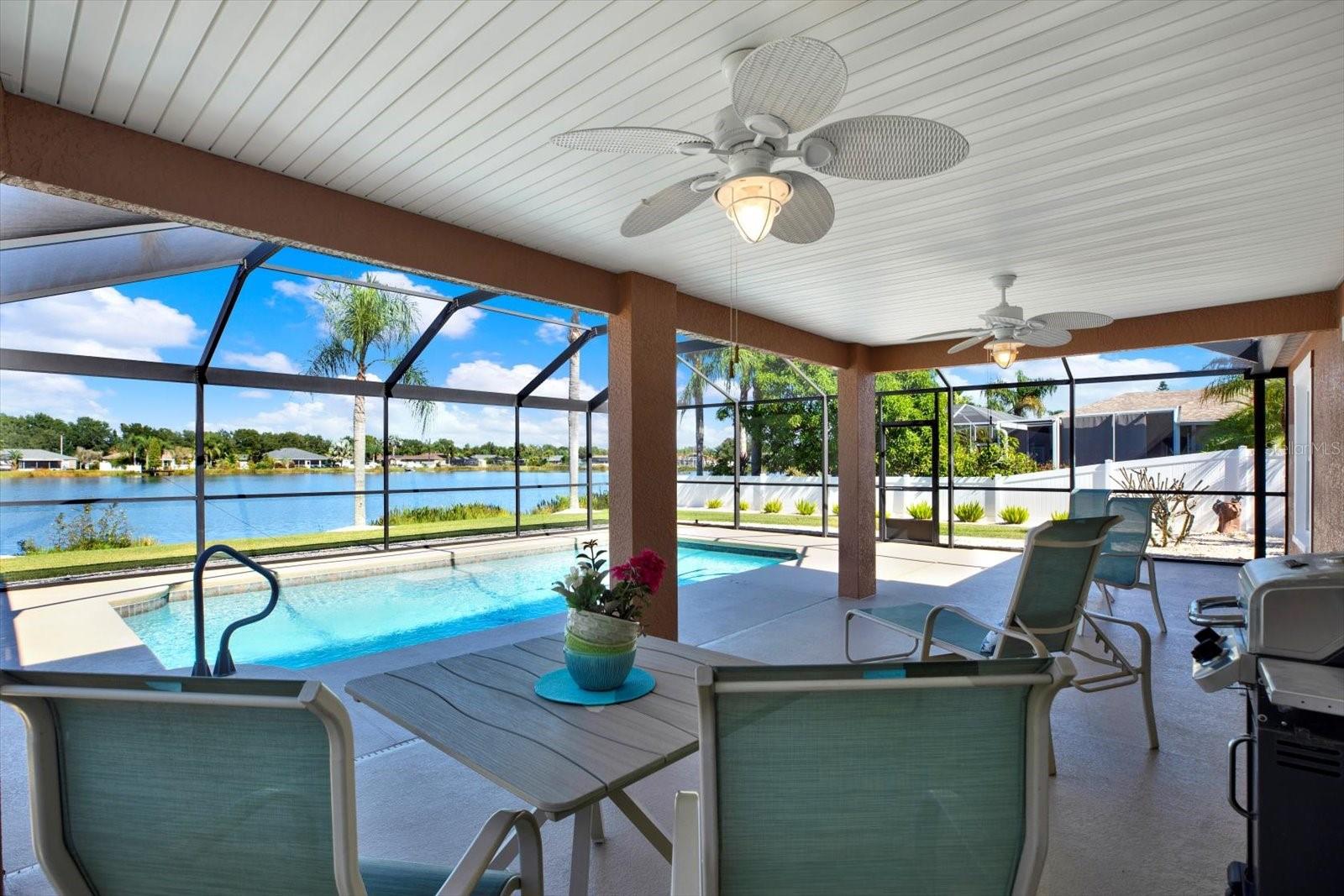 Imagine relaxing in this shady outdoor dining area overlooking the pool and lake.