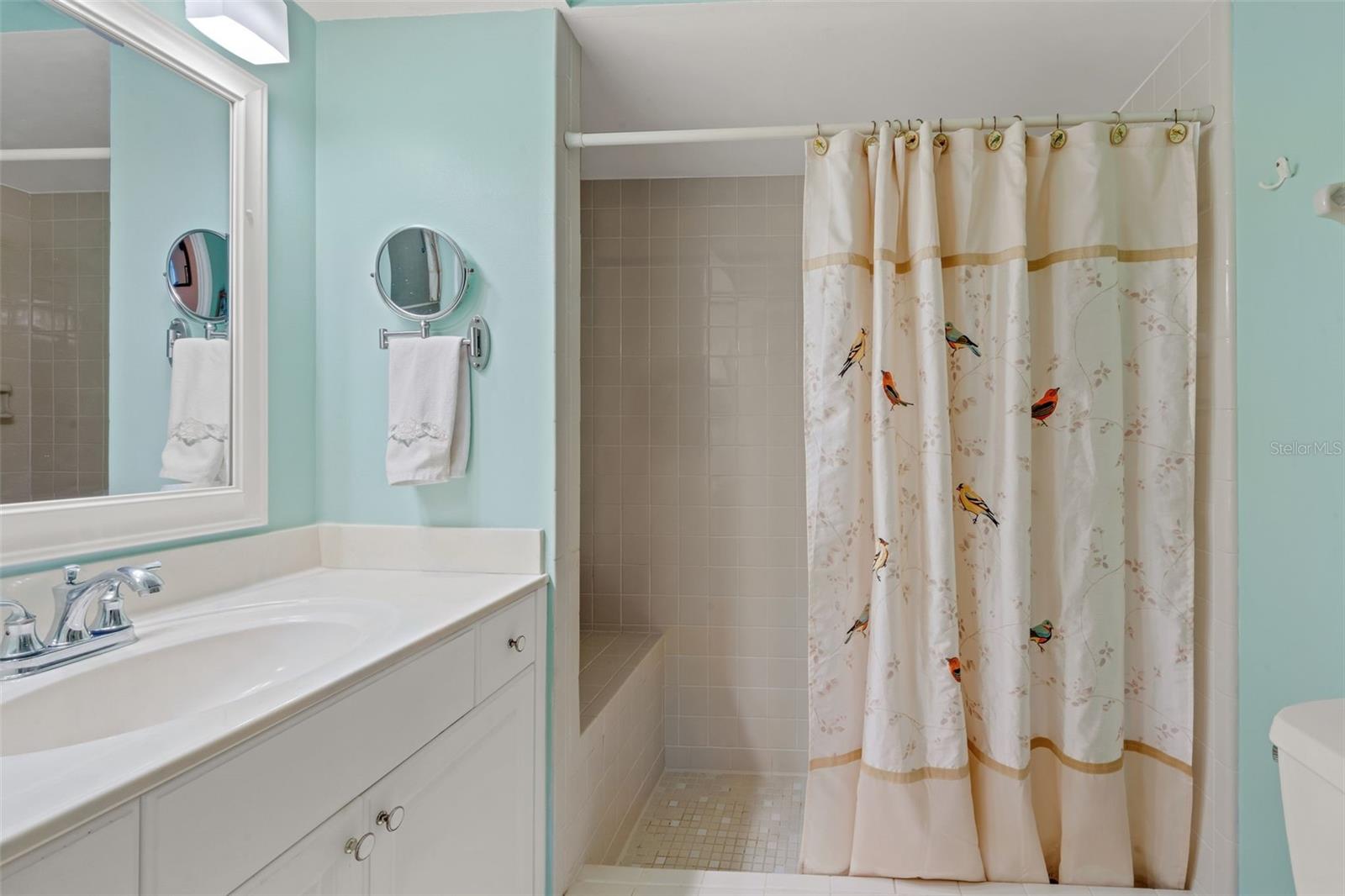 Primary bathroom with shower and built in bench seat