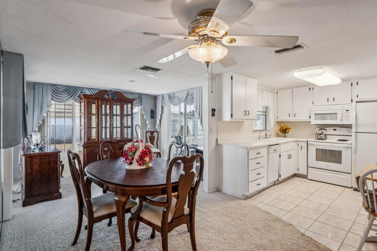 Dining area has a ceiling fan, carpet,