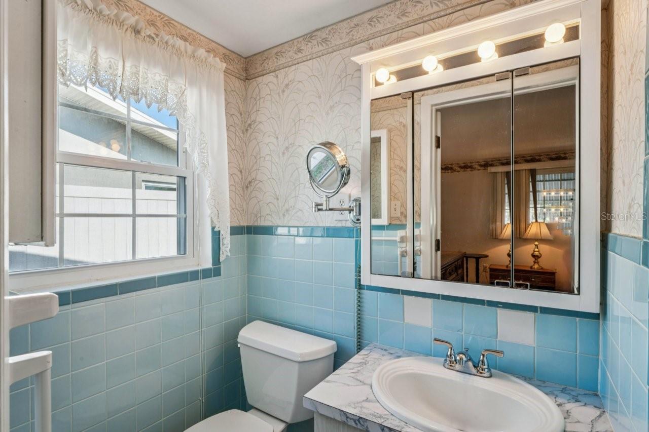 Primary bathroom has tub with shower, window, ceramic tile flooring