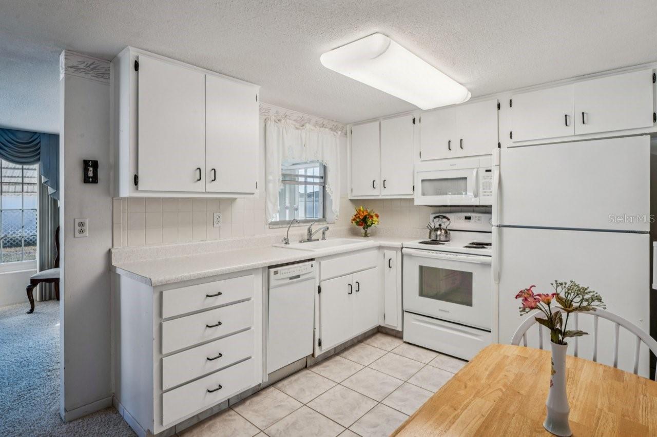 Kitchen has ceramic tile flooring. Notice there is enough room for a table.