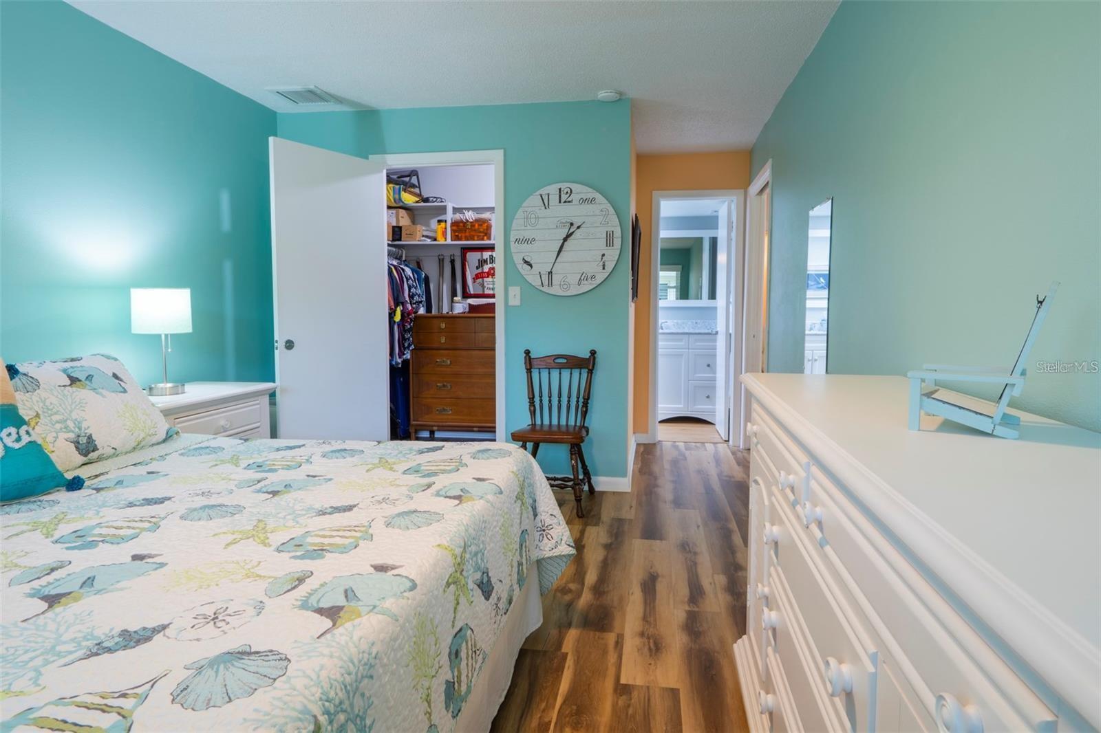 primary bedroom looking into the spacious walk-in closet and ensuite bathroom