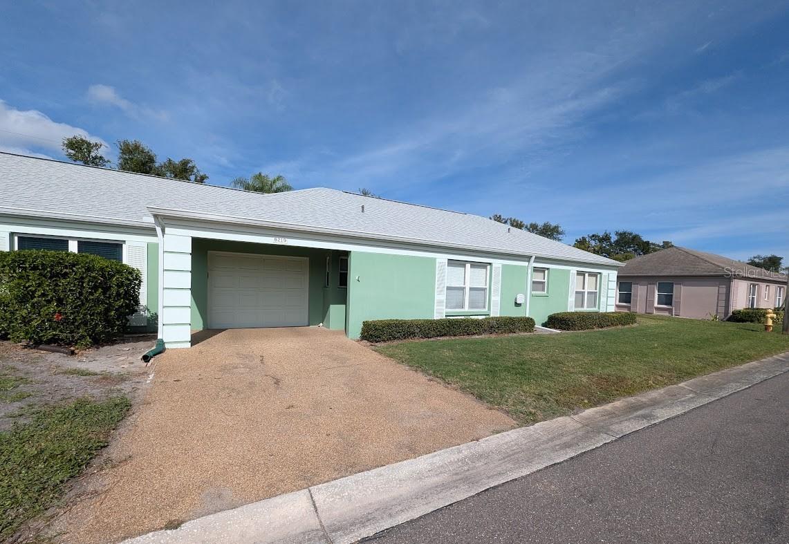 Front exterior with 1 car garage and parking pad