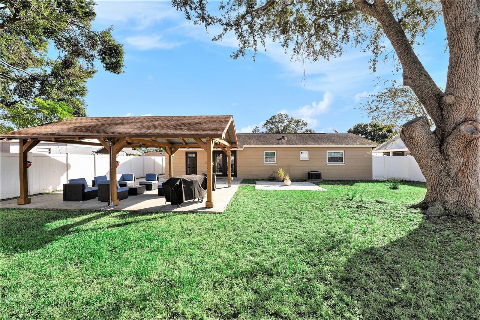 Spacious yard with pergola on a slab.