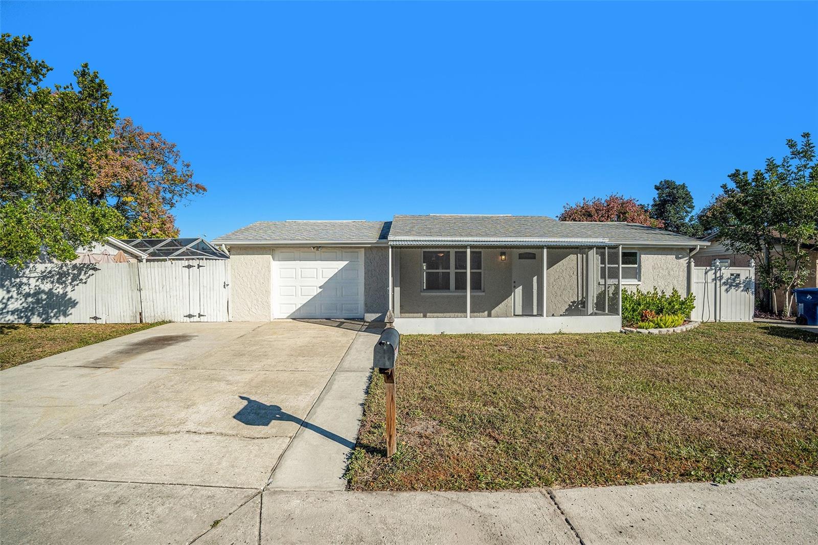 Screened front porch- double driveway- sidewalk- side fences