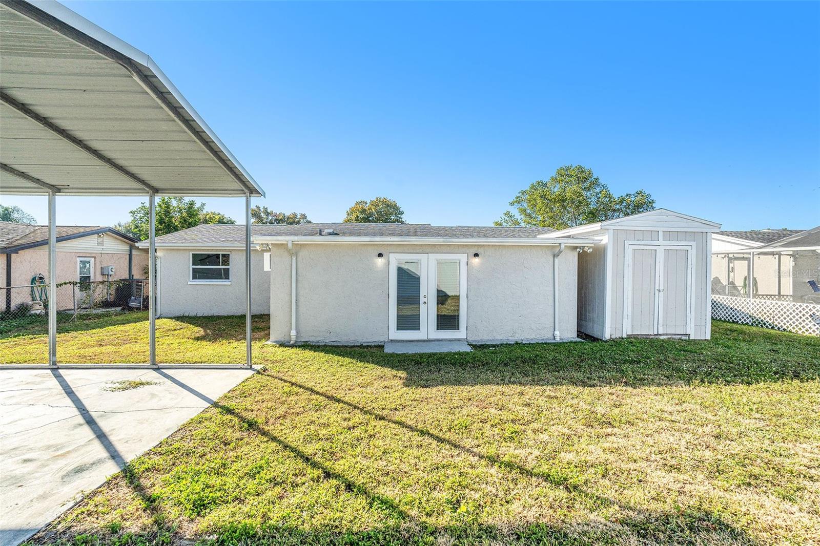Large fenced in backyard with shed and covered pad